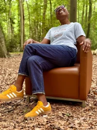 Sylvie Picard dans un fauteuil retapissé mise en scène dans une forêt